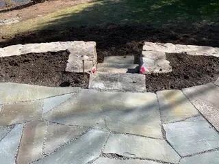 Stone steps under construction between retaining walls