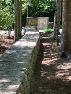 Stone wall path leading to outdoor fireplace