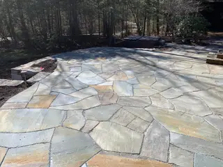 Wide flagstone patio in wooded backyard