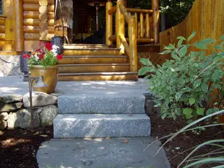 Lantern-lined patio steps at log cabin entrance