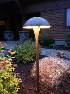 Mushroom-style path light near stone pillars