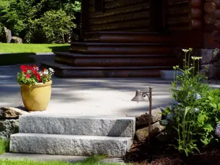 Path light beside granite steps and flowering planter