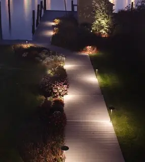 Path lights along lakeside boardwalk at night