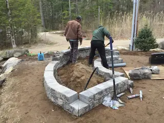 Crew building circular stone retaining wall
