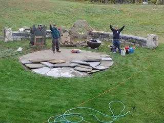 Crew celebrating finished fire pit patio