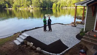 Crew giving thumbs up on finished lakeside paver patio