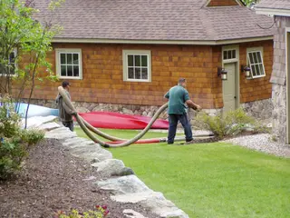 Crew hauling hydro-seeding hoses at property