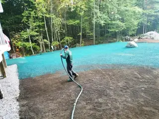 Crew hydro-seeding a cleared backyard