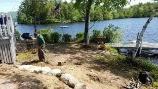 Crew member raking near dock and flagpole