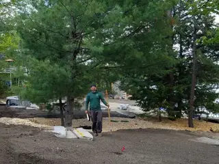 Crew member smiling by lakeside worksite