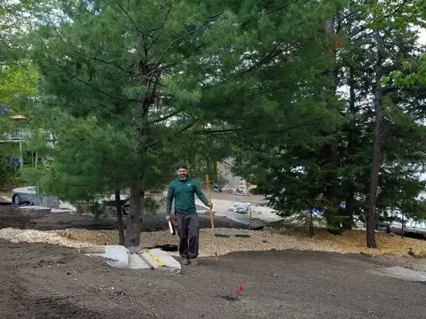 TLE crew member smiling at a lakeside worksite