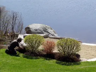 Crew planting shrubs beside lakeside stone steps