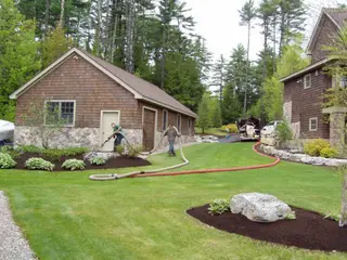 Crew running hydro-seeding hose to work truck