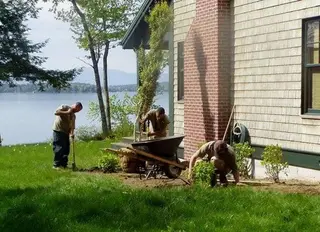 Crew working near brick chimney at lakeside home