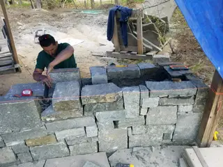 Mason setting stone wall blocks