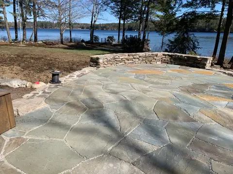 Curved stone seat wall and patio overlooking the lake