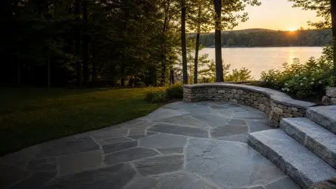 Lakeside flagstone patio with a curved stone seat wall and granite steps