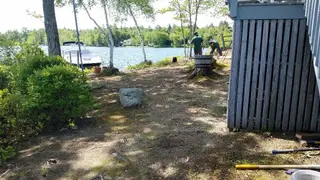 Crew working near lakeside deck stump